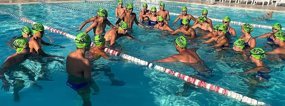 Nuotatori ascoltano una spiegazione tecnica in piscina